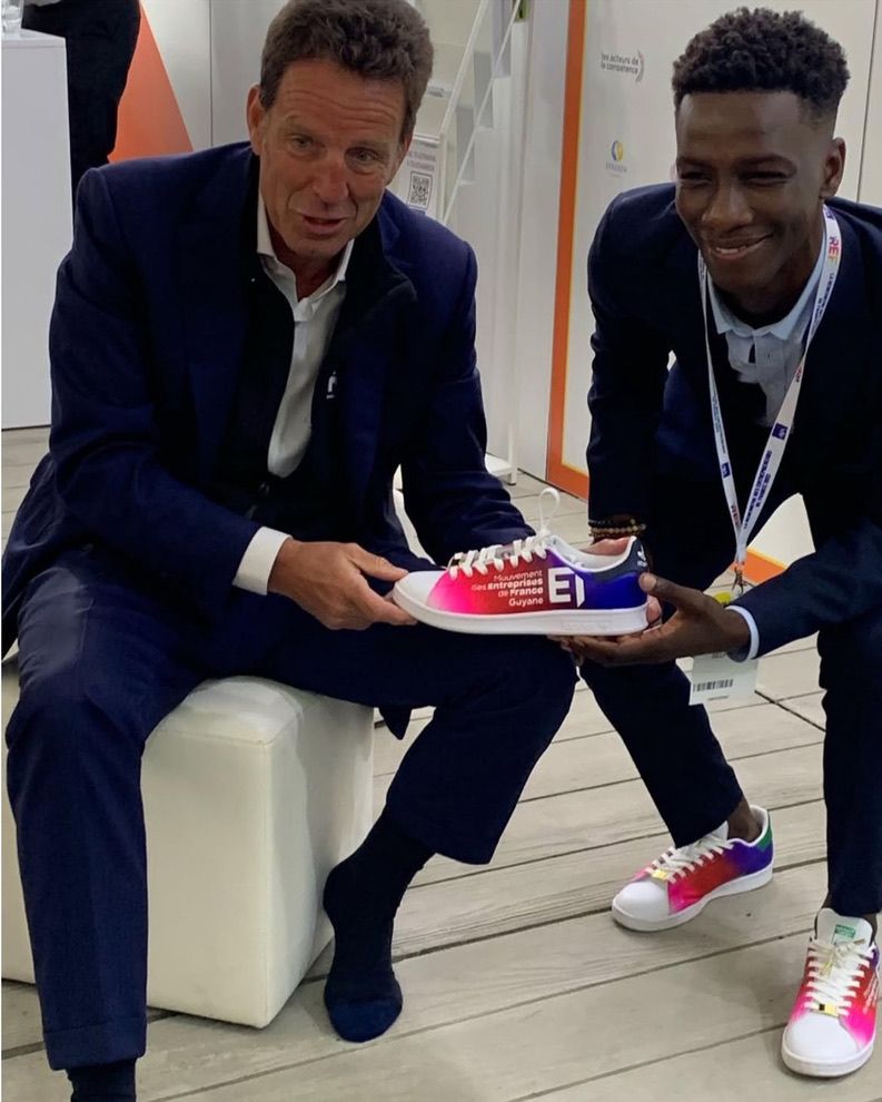 Axel Loupeda remet une basket Belpair aux couleurs du MEDEF Guyane à Geoffroy Roux de Bézieux, lors de la REF 2021